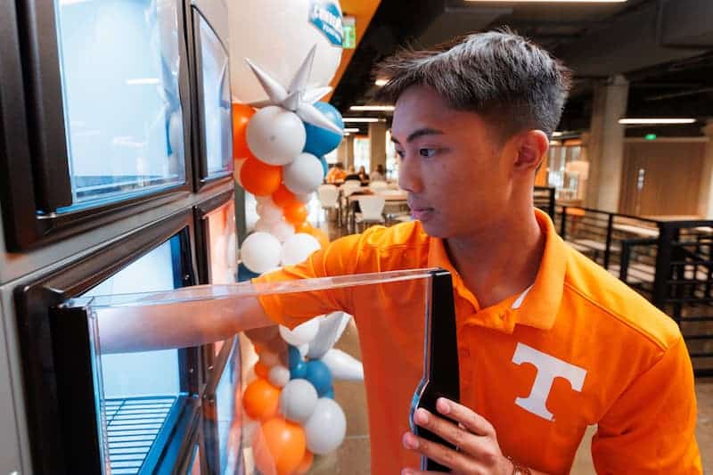 student taking food order out of fridge